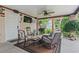 Covered outdoor living space with comfortable seating, ceiling fan, television, and grill is perfect for entertaining at 208 Millwood Dr., Surfside Beach, SC 29575