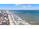 Aerial view showcasing the beach, fishing pier, and coastal homes along the oceanfront at 212 29Th Ave. N # 204, North Myrtle Beach, SC 29582