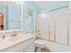 Bright bathroom with blue walls, a single sink vanity, and a shower-tub combo with sliding glass doors at 212 29Th Ave. N # 204, North Myrtle Beach, SC 29582