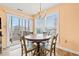 Dining room with a round table, natural wood chairs, chandelier, and view to an outdoor balcony at 212 29Th Ave. N # 204, North Myrtle Beach, SC 29582