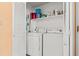 Bright laundry room with white appliances and shelving for storage inside an open, shuttered closet at 212 29Th Ave. N # 204, North Myrtle Beach, SC 29582