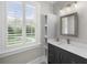 Well-lit bathroom with a gray vanity, modern fixtures, a large mirror, and a window with shuttered blinds at 288 Tipperary Pl., Pawleys Island, SC 29585