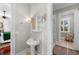 Bathroom featuring a pedestal sink, sconce lighting, medicine cabinet and entryways to adjoining spaces at 288 Tipperary Pl., Pawleys Island, SC 29585
