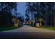 Well-lit driveway leads to a grand home, enhanced by elegant stone columns and manicured landscaping at 288 Tipperary Pl., Pawleys Island, SC 29585