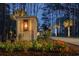 Entry monument with an illuminated lantern, flowers and a view of the home in the distance at twilight at 288 Tipperary Pl., Pawleys Island, SC 29585