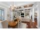 Open-concept living room with fireplace, built-in shelving, wood floors, and dining area at 288 Tipperary Pl., Pawleys Island, SC 29585