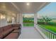 Inviting covered porch with comfortable seating offers serene views of the lush, green landscape at 288 Tipperary Pl., Pawleys Island, SC 29585
