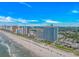 Stunning aerial view of high-rise beachfront resorts with sandy beaches, clear ocean waters, and blue skies at 3000 N Ocean Blvd. # 1127, Myrtle Beach, SC 29577