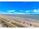 A wide beach view showcasing a lifeguard station surrounded by colorful umbrellas, and ocean waves at 3000 N Ocean Blvd. # 1127, Myrtle Beach, SC 29577