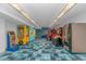 Bright game room with classic arcade games and vibrant blue carpeting for Gathering entertainment at 3000 N Ocean Blvd. # 1127, Myrtle Beach, SC 29577