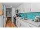Contemporary kitchen featuring white cabinetry, stainless steel appliances, and a bright turquoise backsplash at 3000 N Ocean Blvd. # 1127, Myrtle Beach, SC 29577