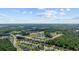A captivating aerial view showcasing homes in a lakeside community surrounded by dense trees under a bright, partly cloudy sky at 305 Forestbrook Cove Circle, Myrtle Beach, SC 29588