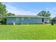 Back exterior view showing a flat, grassy backyard with a small patio area at 308 Sanders Ct., Mullins, SC 29574