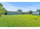 Wide open, grassy backyard with home, shed, and neighboring home in view at 308 Sanders Ct., Mullins, SC 29574