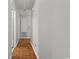 Hallway with wood floors, neutral walls, access to a storage closet, and provides passage through the home at 308 Sanders Ct., Mullins, SC 29574