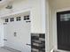 Close up on the two-car garage with carriage doors, stone accents and an overhead light fixture at 3137 Tiger Tail Rd., Conway, SC 29526