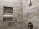 Detailed view of a shower with tiled walls, built-in shelving, and modern fixtures at 3137 Tiger Tail Rd., Conway, SC 29526