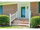 Welcoming front entrance with brick steps, white railings, and a glass-paneled door, exuding charm at 324 Camellia Ave., Marion, SC 29571