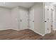 Bright hallway featuring modern wood flooring and multiple white doors, enhancing functionality and style at 324 Camellia Ave., Marion, SC 29571