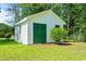 Charming outbuilding featuring white siding, green doors, and surrounding greenery, offering extra space at 324 Camellia Ave., Marion, SC 29571