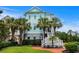 Beautiful three-story beach house with striking blue exterior and palm trees at 350 Saint Julian Ln., Myrtle Beach, SC 29579
