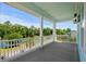 Wide porch view with white railing looking out over a pond with green trees and a blue house at 350 Saint Julian Ln., Myrtle Beach, SC 29579