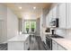 Bright kitchen featuring white cabinetry, an island with counter seating, and a cozy breakfast nook at 3647 Diamond Stars Way, Little River, SC 29566