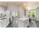 Contemporary kitchen with white cabinets, an island, stainless steel appliances, and access to the patio at 3647 Diamond Stars Way, Little River, SC 29566
