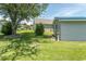 Landscaped backyard featuring lush green grass, mature trees and a storage shed at 3879 Mallard Way, Little River, SC 29566