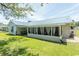 Exterior side view of home featuring screened in porch and lush, landscaped lawn at 3879 Mallard Way, Little River, SC 29566