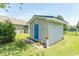 Exterior view of storage shed with a blue door, green grass and tasteful landscaping at 3879 Mallard Way, Little River, SC 29566