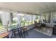 Enclosed sunroom with neutral walls, seating arrangements, and serene views of the outdoors at 3879 Mallard Way, Little River, SC 29566