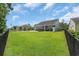 Spacious, green backyard featuring a black fence, hot tub, patio and tidy lawn at 3925 Riley-Hampton Dr., Myrtle Beach, SC 29579