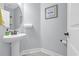 Powder room featuring a pedestal sink, round mirror, and neutral wall art at 3925 Riley-Hampton Dr., Myrtle Beach, SC 29579