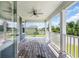 Inviting covered porch with wood flooring, ceiling fan, and classic white railing overlooking the landscaped yard at 3925 Riley-Hampton Dr., Myrtle Beach, SC 29579