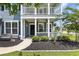 Inviting front porch with white columns, ceiling fans, hanging plants, and a neatly landscaped garden at 3925 Riley-Hampton Dr., Myrtle Beach, SC 29579