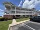 Three-story condo building with white railing balconies, brick facade, and manicured landscaping at 3965 Forsythia Ct. # 202, Myrtle Beach, SC 29588