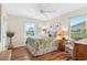 Bright bedroom featuring a patterned bedspread, a ceiling fan, and a green vase at 401 Marlin St., Sunset Beach, NC 28468