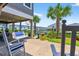 Home's cozy back patio with swing, rocking chairs, landscaping, and views of the waterway and neighborhood at 401 Marlin St., Sunset Beach, NC 28468