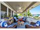 Inviting covered porch featuring comfortable seating, ceiling fans, and scenic views of the surrounding landscape at 401 Marlin St., Sunset Beach, NC 28468