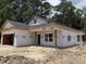 Exterior view of new construction with a covered porch held up by wooden posts and a two-car garage at 4032 Copperhead Rd., Conway, SC 29527