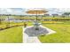 Green backyard featuring a patio, well-manicured lawn, and scenic pond views at 435 Rollins Dr., Longs, SC 29568