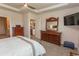 Bright bedroom with a wooden dresser, plush carpet, and a glimpse into the modern kitchen at 435 Rollins Dr., Longs, SC 29568