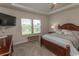 Spacious bedroom with tray ceilings, carpet, a large window, and a dark wooden bed frame at 435 Rollins Dr., Longs, SC 29568