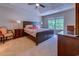 Main bedroom featuring a large window, dark furniture, a fan, and tray ceilings at 4355 Rivergate Ln. # F, Little River, SC 29566