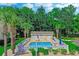 Community pool area featuring a fenced-in pool with lounge chairs and umbrellas, surrounded by lush greenery at 4355 Rivergate Ln. # F, Little River, SC 29566