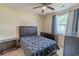 This cozy bedroom features neutral walls, a ceiling fan, and a window with blue curtains at 468 River Oak Dr. # 66D, Myrtle Beach, SC 29579