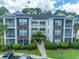 Attractive multi-story condo building with brick accents, white trim, well-maintained landscaping, and a walkway at 468 River Oak Dr. # 66D, Myrtle Beach, SC 29579