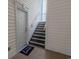 Well-lit exterior stairwell with gray stairs, a white handrail, and a doormat that says, 'It's good to be home' at 468 River Oak Dr. # 66D, Myrtle Beach, SC 29579