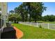 Charming backyard with a well-maintained lawn, white picket fence, and views of lush green trees at 483 Oakmont Dr., Myrtle Beach, SC 29579